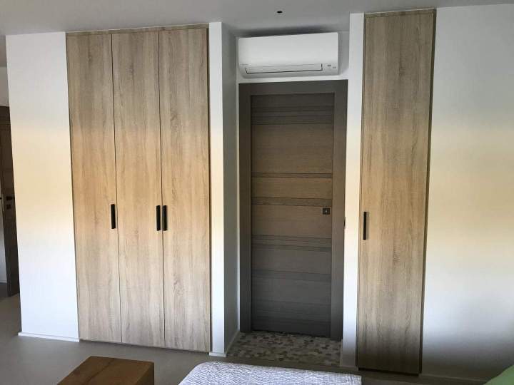 Aménagement intérieur moderne avec des placards intégrés en bois clair Porto-Vecchio        