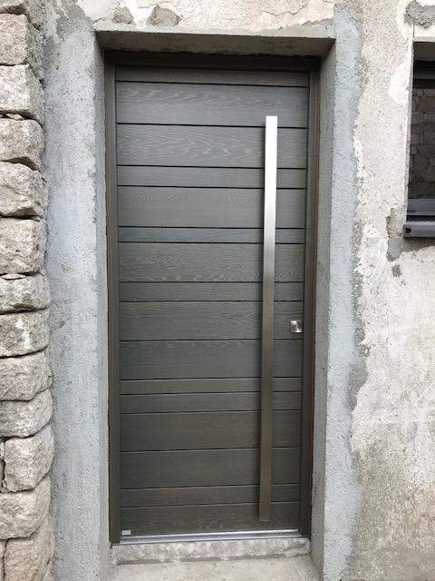 Pose de porte d'entrée moderne avec de longue poignée de tirage verticale en métal Porto-Vecchio